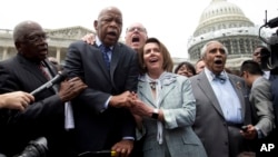 From left, House Assistant Minority Leader James Clyburn, Rep. John Lewis, D-Ga., Rep. Joseph Crowley, D-N.Y., House Minority Leader Nancy Pelosi of California, and Rep. Charles Rangel, D-N.Y., sing "We Shall Overcome" on Capitol Hill, in Washington, June