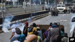 Demonstrators throw stones towards Venezuelan Bolivarian National Police officers during a protest in Caracas, Venezuela, April 8, 2017. 