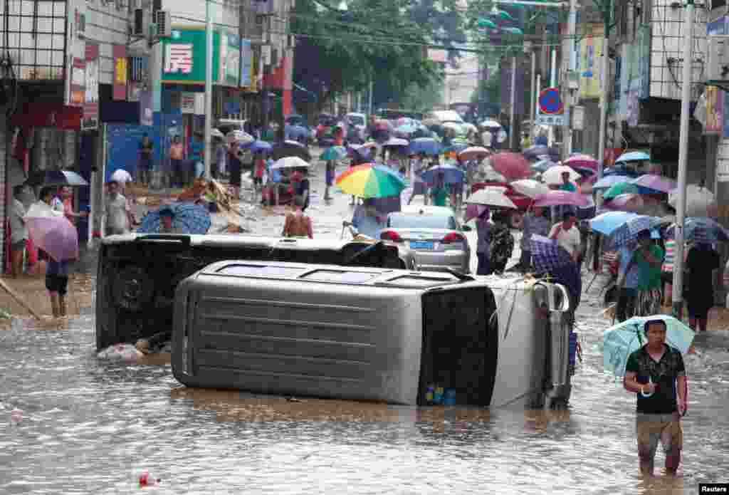 Automobiles are seen overturned on a flooded street in Liuzhou, Guangxi Zhuang Autonomous Region, China.