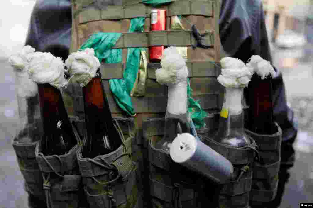 An Iraqi demonstrator carries molotov cocktails during ongoing anti-government protests in Baghdad.