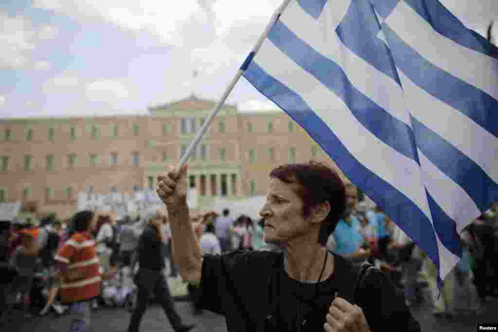 An anti-austerity protester holds a Greek flag during a rally in Athens, July, 16, 2013.