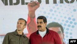 FILE - Venezuelan President Nicolas Maduro, right, and his Vice President Tareck El Aissami participate in a rally with workers of PDVSA state-owned oil company in Caracas, Jan. 31, 2017.