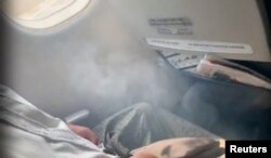 Smoke enters the cabin as passengers wait to evacuate after Myanmar National Airlines flight UB103 landed without a front wheel at Mandalay International Airport in Tada-U, Myanmar, May 12, 2019 in this image taken from social media video.