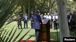 Embassy workers listen to Britain's Foreign Secretary Philip Hammond during the reopening of the British Embassy in Tehran, Iran, Aug. 23, 2015. 