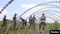 Le contingent sud-africain de soldats de la paix au Congo érige une barrière de fils barbelés autour de l'aéroport de Goma en RDC, le 26 novembre 2012.