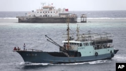 Sebuah kapal nelayan melintasi wilayah karang Meiji dekat propinsi Hainan di Laut China Selatan (Foto: dok). Vietnam menuduh China merusak sebuah kapal nelayan, setelah sebuah kapal China menabrak kapal tersebut saat melintasi perairan Vietnam 20 Mei yang lalu. 