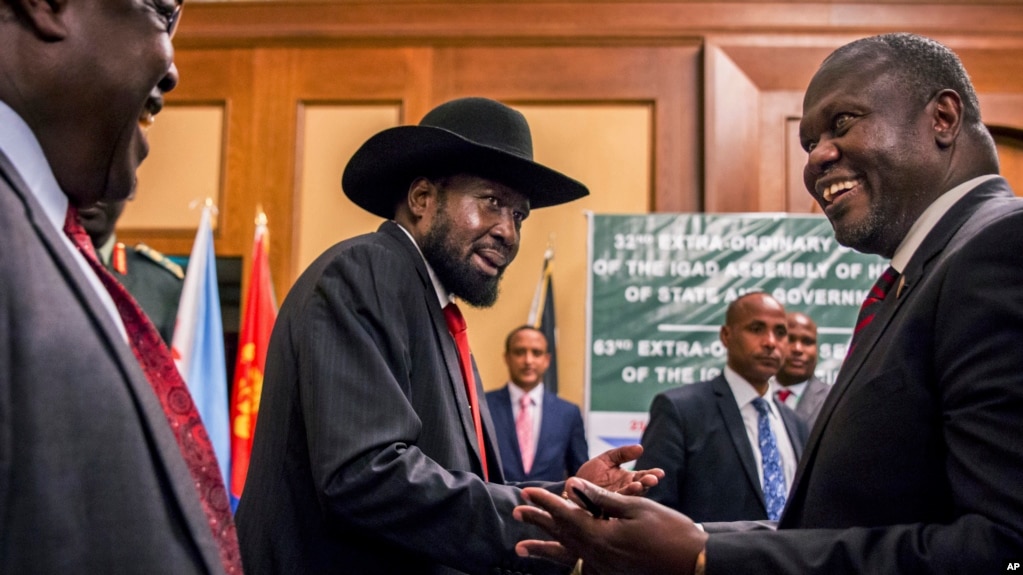 Le président du Soudan du Sud, Salva Kiir, et le chef de l'opposition Riek Machar, à droite, se serrent la main lors des pourparlers de paix dans un hôtel à Addis Abeba, Ethiopie, 21 juin 2018. 