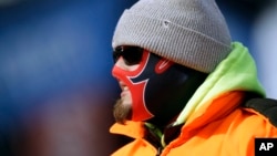 A fan is bundled against the cold weather at an NFL football game between the New England Patriots and the New York Jets, Dec. 31, 2017, in Foxborough, Mass. 