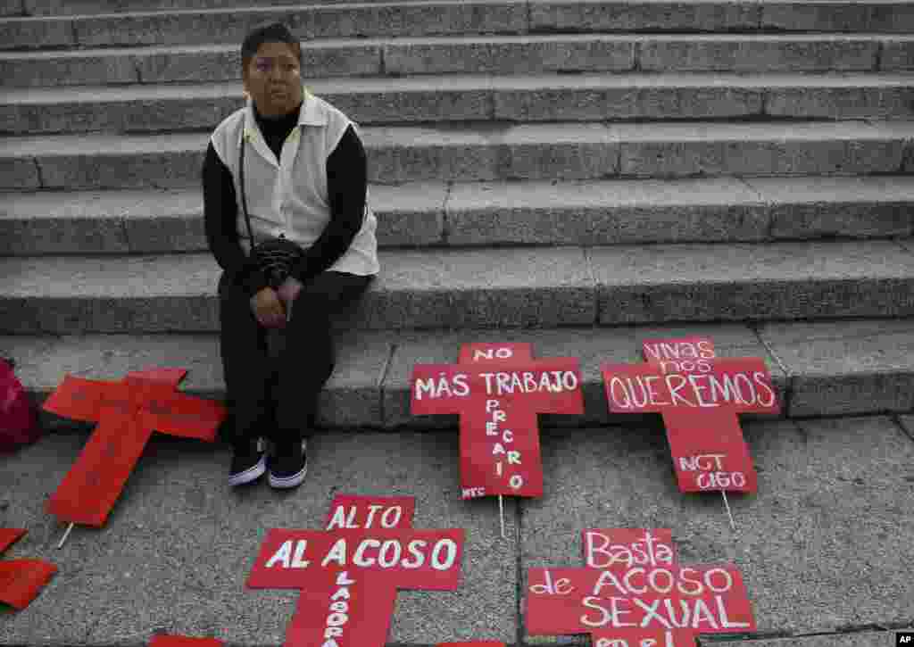 Seorang perempuan menunggu dimulainya protes melawan kekerasan terhadap perempuan di Mexico City (25/11). (AP/Marco Ugarte)