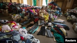 Ukrajinac isprobava odeću dodeljenu ugroženim civilima u području Donjecka na istoku zemlje. 