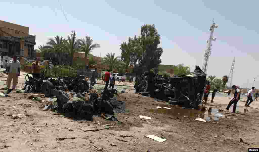 People gather at the site of a car bomb attack in Baghdad, August 15, 2013.