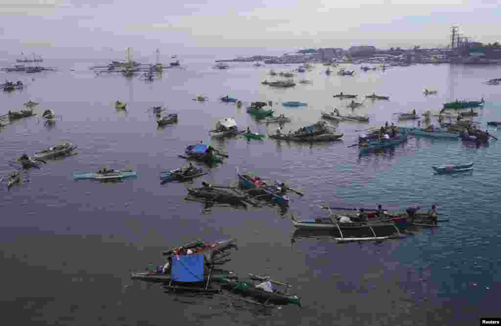 Warga desa dengan menggunakan perahu tiba di pelabuhan Zamboanga setelah mengungsi akibat pertempuran antara tentara pemerintah Filipinan dan pemberontak Moro di kota Zamboanga, Filipina selatan.
