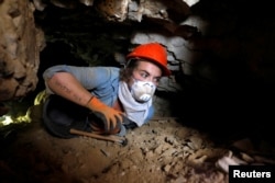 A woman, part of a group of volunteers and archaeologists, works at an archaeological dig near caves in the Qumran area, in the Israeli-occupied West Bank January 15, 2019. Picture taken January 15, 2019. REUTERS/Ronen Zvulun