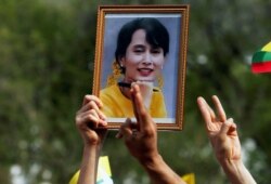 Seseorang memegang foto pemimpin Aung San Suu Kyi saat warga Myanmar memprotes kudeta militer di depan kantor PBB di Bangkok, Thailand, 22 Februari 2021. (Foto: Reuters)