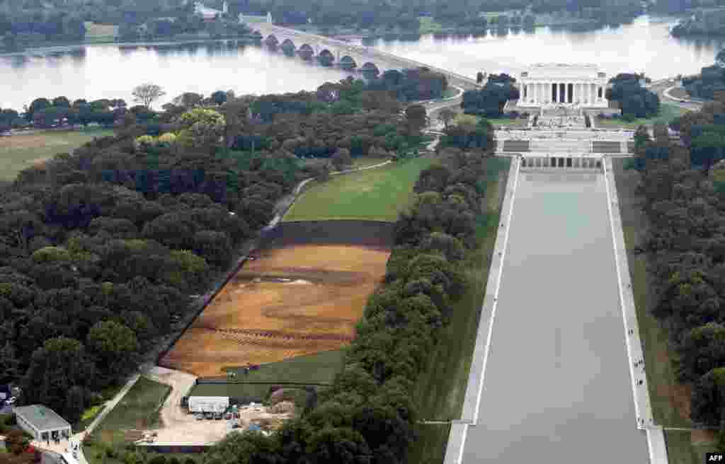 The landscape portrait, "Out of Many, One" by Cuban American artist Jorge Rodriguez-Gerada, appears on the National Mall in Washington, D.C., Oct. 1, 2014. The 6-acre portrait, midway between the World War II Memorial and the Lincoln Memorial, used approximately 2,000 tons of sand, 800 tons of soil, 10,000 wooden pegs, miles of string and assistance from GPS topography poles, which allows the materials to be placed with precision. It will be viewable until October 31.