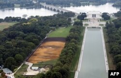 The landscape portrait, "Out of Many, One" by Cuban American artist Jorge Rodriguez-Gerada, appears on the National Mall in Washington, DC, October 1, 2014, as viewed from the Washington Monument. The 6-acre portrait, midway between the World War II Memor