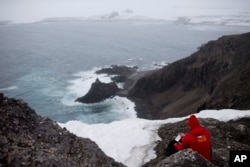 FILE - In this Jan. 24 2015, photo, German scientist Andreas Beck takes notes in Robert Island, in the South Shetland Islands archipelago, Antarctica. Antarctica holds 90 percent of the world’s ice.