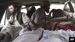 Warga di distrik Alingar, provinsi Laghman, Afghanistan membawa para perempuan korban serangan udara NATO ke rumah sakit setempat hari Minggu (16/9).