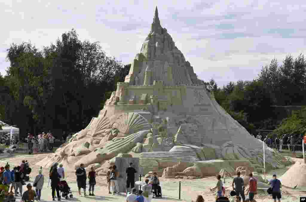 People watching a giant sandcastle in Duisburg, Germany, Friday, Sept. 2, 2016. The castle was made of 2300 tons of sand.