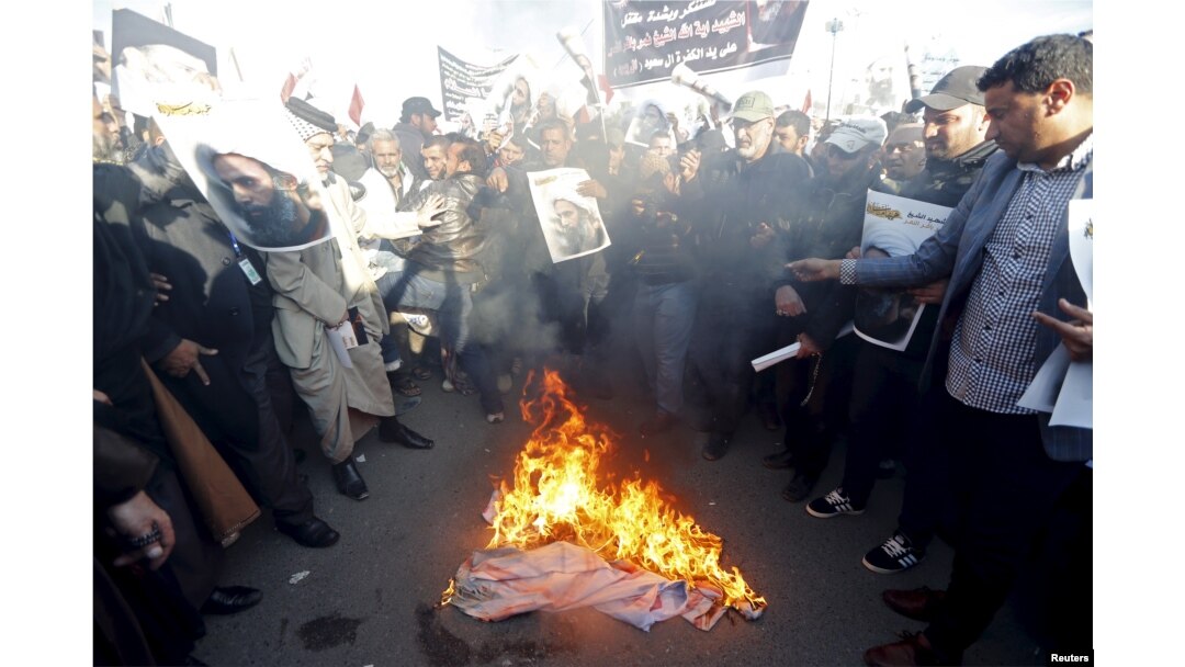 Supporters of Shi'ite cleric Moqtada al-Sadr burn fabric painted to resemble the national flags of Israel, the United Kingdom and the U.S. during a demonstration condemning the execution of Shi'ite cleric Nimr al-Nimr in Saudi Arabia, in Baghdad, Jan. 4, 2016.