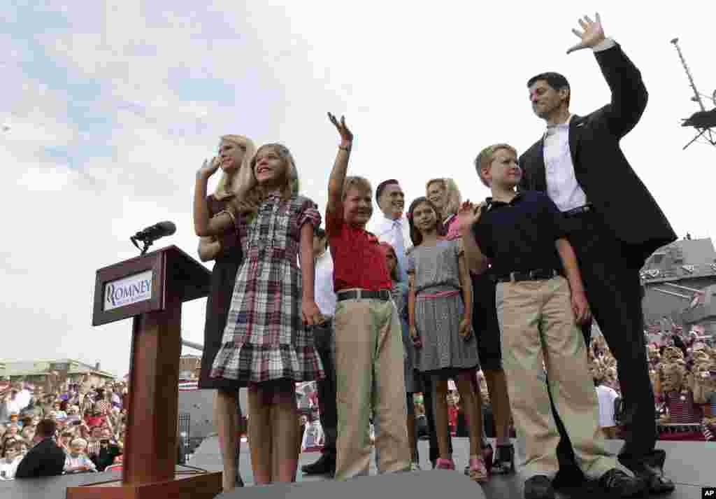 Paul Ryan, and his family, and Republican presidential candidate, former Massachusetts Gov. Mitt Romney and his family, partially visible at center back, wave to the crowd, Aug. 11, 2012, in Norfolk, Va.