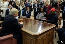 Rapper Kanye West (R) speaks to President Donald Trump and others in the Oval Office of the White House, Oct. 11, 2018, in Washington.