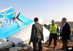 In this image released by the Prime Minister's office, Sherif Ismail, right, looks at the remains of a crashed passenger jet in Hassana Egypt, Friday, Oct. 31, 2015.