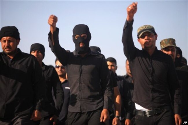 FILE - Volunteers train at military base in the Shi'ite holy city of Najaf, 100 miles south of Baghdad, Iraq, June 17, 2014.