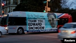 A Washington Metro bus is seen with an Edward Snowden sign on its side panel, Dec. 20, 2013.