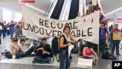 Para demonstran memblokir eskalator bandara di San Francisco, California (29/1), sebagai protes atas larangan masuk AS bagi warga tujuh negara berpenduduk mayoritas Muslim.