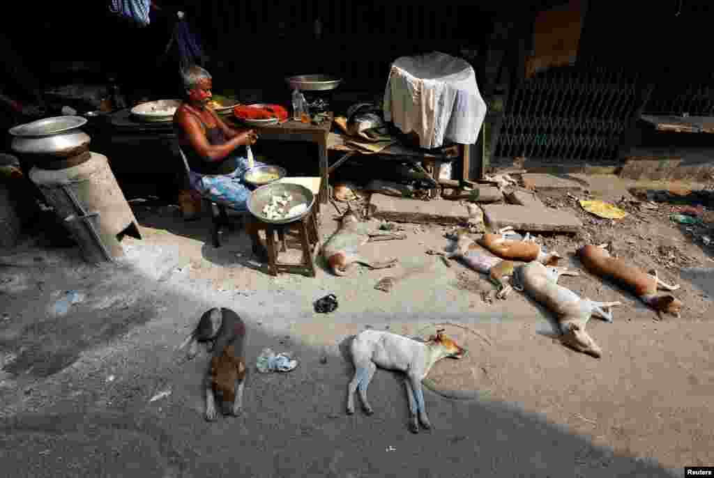 Seorang pria menyiapkan bahan makanan untuk dimasak di sebuah warung pinggir jalan di Kolkata, India.