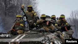 Members of the Ukrainian armed forces ride on an armoured personnel carrier (APC) near Debaltseve, eastern Ukraine, February 10, 2015. Ukrainian President Petro Poroshenko said peace talks in Minsk on Wednesday were one of the last chances to declare an u