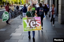 A woman carries a placard as Ireland holds a referendum on liberalizing abortion laws, in Dublin, May 25, 2018.