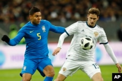 Russia's Aleksey Miranchuk, right and Brazil's Casemiro challenge for the ball during an international friendly soccer match between Russia and Brazil at the Luzhniki stadium in Moscow, Russia, Friday, March 23, 2018. (AP Photo/Pavel Golovkin)