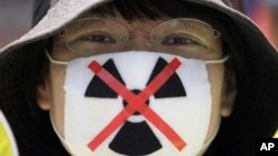 An anti-nuclear protester waits to begin a march through downtown Tokyo, Japan, July 16, 2012. 
