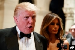 Melania Trump, right, looks on as her husband President-elect Donald Trump talks to reporters during a New Year's Eve party at Mar-a-Lago, Dec. 31, 2016, in Palm Beach, Florida.