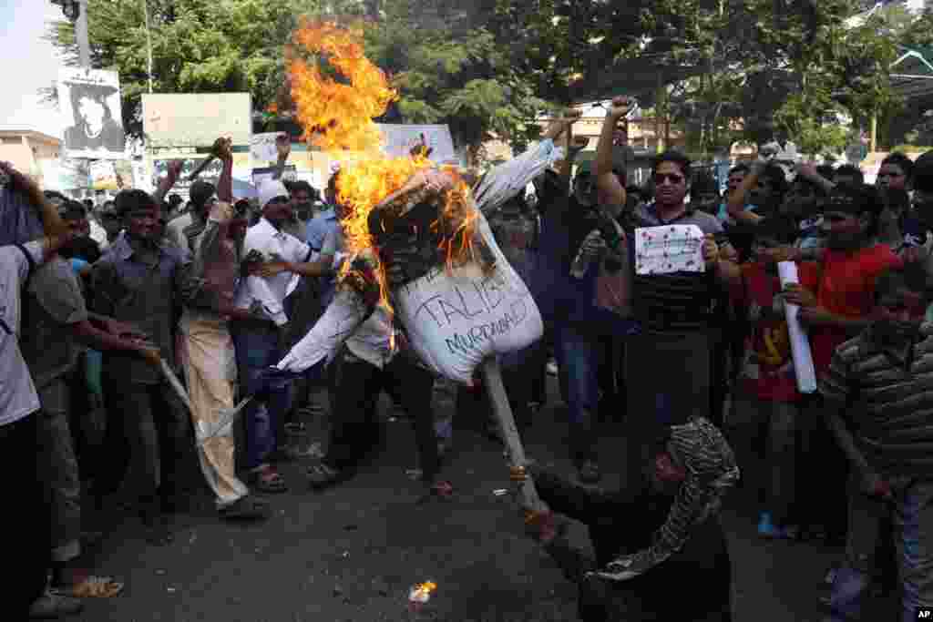 Protesters from Pakistan&#39;s Christian community burn a Taliban effigy to condemn a suicide bombing on a Peshawar church, in Karachi, Sept. 23, 2013. 