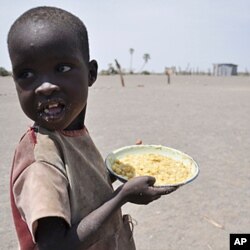 FILE—A young boy walks away with his food from a government sponsored feeding center in central Turkana, Kenya, August 30, 2011