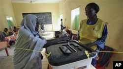 An elderly Southern Sudanese woman casts her vote Monday in a ballot box at a polling center in the city of Um Durman, Sudan, Jan. 10, 2011