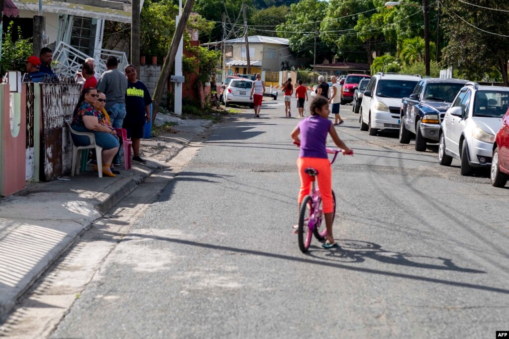 Se pueder ver a personas afuera de sus casas en un vecindario donde las casas fueron dañadas por un terremoto de 5.8 en Guánica, Puerto Rico el 6 de enero de 2020.