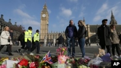People view floral tributes to victims of Wednesday's attack outside the Houses of Parliament in London, March 24, 2017. On Thursday authorities identified a 52-year-old Briton as the man who mowed down pedestrians and stabbed a policeman to death outside Parliament in London.
