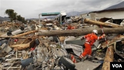 Un socorrista británico busca entre los escombros indicios de sobrevivientes en la devastada ciudad portuaria de Ofunato.