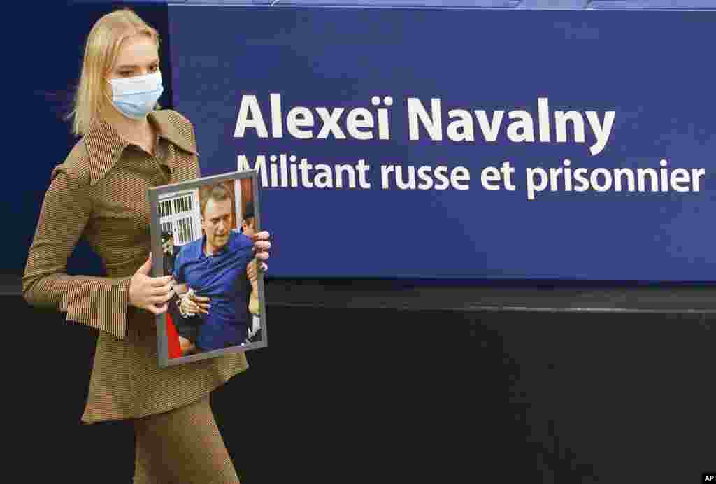 Daria Navalnaya, the daughter of jailed Russian opposition leader Alexey Navalny, carries a portrait of her father at the European Parliament in Strasbourg, eastern France. Daria Navalnaya will receive the Sakharov Prize for Freedom of Thought Award, the European Union top human rights prize, on behalf of her father.