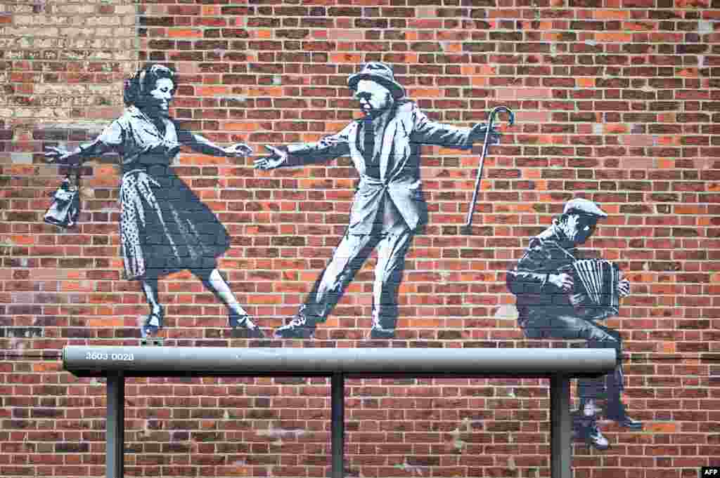 A graffiti artwork of a couple dancing and an accordion player, which bears the hallmarks of street artist Banksy, is seen on a wall in Great Yarmouth on the East coast of England.