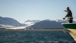 Former President Barack Obama looks at Bear Glacier while on a boat tour seeing the effects of climate change in Resurrection Cove, Tuesday, Sept. 1, 2015, in Seward, Alaska.