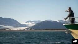 Former President Barack Obama looks at Bear Glacier while on a boat tour seeing the effects of climate change in Resurrection Cove, Tuesday, Sept. 1, 2015, in Seward, Alaska.
