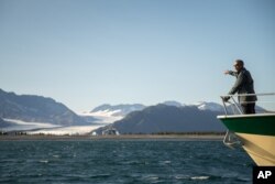 President Barack Obama looks at Bear Glacier, which has receded 1.8 miles in approximately 100 years, while on a boat tour to see the effects of global warming in Resurrection Cove, Tuesday, Sept. 1, 2015, in Seward, Alaska.