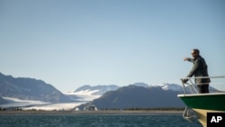 FILE - President Barack Obama looks at Bear Glacier, which has receded 1.8 miles in approximately 100 years, while on a boat tour to see the effects of global warming in Resurrection Cove, Seward, Alaska, Sept. 1, 2015.