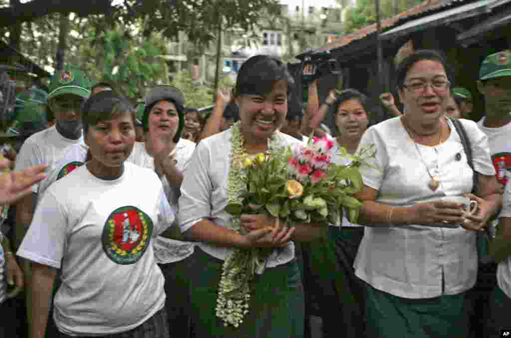 Le Le Aye, center, a candidate of the military-backed Union Solidarity and Development Party (USDP), waves to supporters during her campaign for the April 1 by-election, March 29, 2012, in Rangoon. (AP)