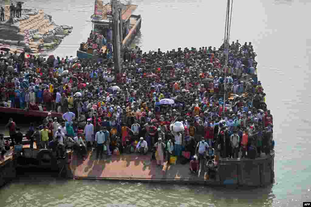 People wait to board a ferry to their hometowns ahead of the Eid al-Fitr festivities amid Covid-19 coronavirus pandemic in Munshiganj, Bangladesh.